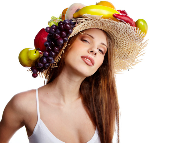 πλάνο του μια όμορφη νεαρή γυναίκα με φρούτα καπέλα. έννοια των τροφίμων, υγείας. - Φωτογραφία, εικόνα