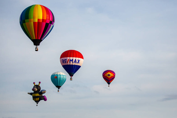 Marathon City, Wisconsin, USA, 10 Ιουλίου 2021: Taste N Glow Balloon Fest. Μπαλόνια θερμού αέρα γεμίζουν τον ουρανό στο κεντρικό Ουισκόνσιν, οριζόντια - Φωτογραφία, εικόνα