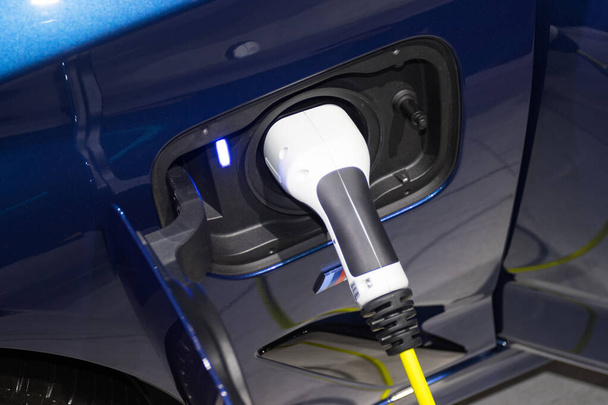o carregamento da bateria para o carro novas inovações automotivas a fonte de alimentação conectada a um carro elétrico que está sendo carregado, conceito de inovação energética. - Foto, Imagem
