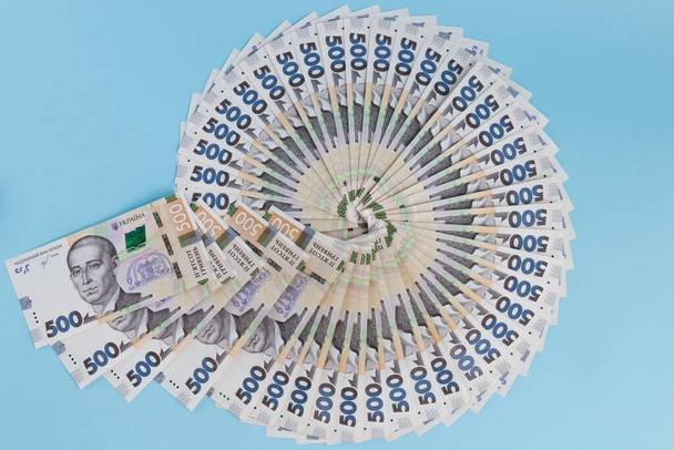 Cirkel van Oekraïens geld. Op een blauwe achtergrond. - Foto, afbeelding