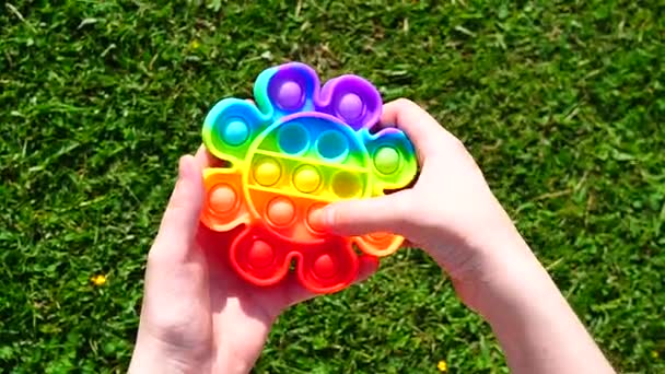 Le mani premono i brufoli di gomma sul giocattolo pop it, in tempo reale - Filmati, video