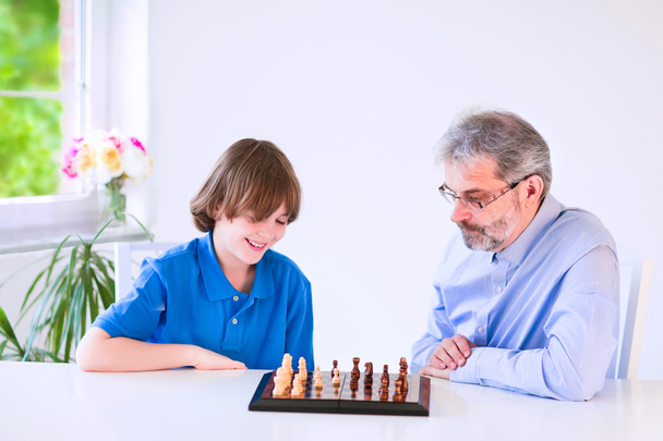Feliz abuelo jugando ajedrez con su nieto
 - Foto, imagen