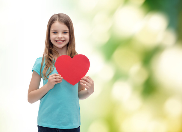 smiling little girl with red heart - Foto, afbeelding