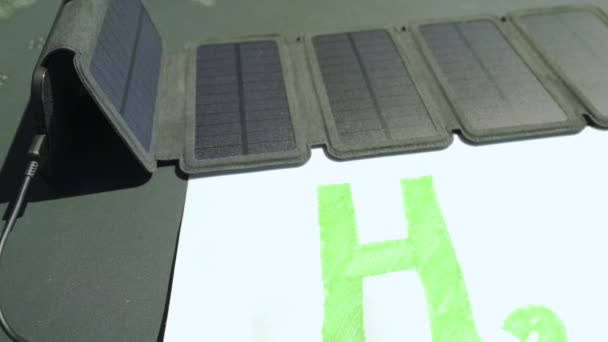 Yeşil hidrojen konsepti. Güneş paneli H2 metnine bağlı, fosil yakıtlar olmadan güneş enerjisinden hidrojen üretimini sembolize ediyor. - Video, Çekim