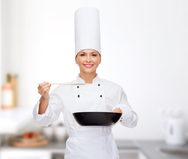 smiling female chef with pan and spoon - Foto, imagen
