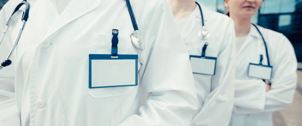 group of medical specialists with blank badges standing in a row. close up. - Foto, immagini