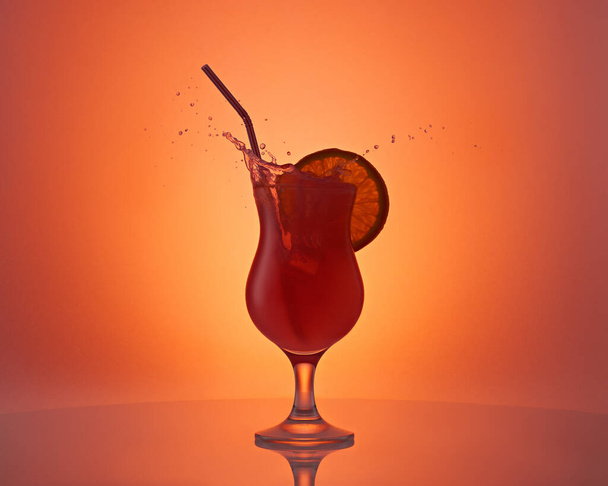 Hermosa copa con cóctel naranja, rebanada de naranja y salpicaduras sobre fondo naranja. Fiesta, entretenimiento. Bebida tónica fresca.  - Foto, imagen