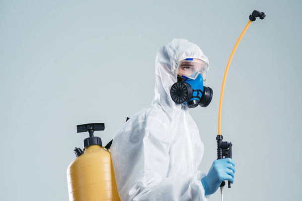 Specialist in a hazmat suit disinfecting with a spraying device. - Fotografie, Obrázek