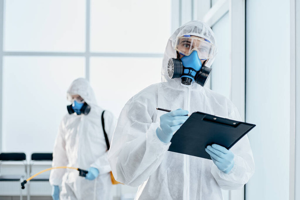 professional disinfector taking notes on the clipboard. - Photo, Image