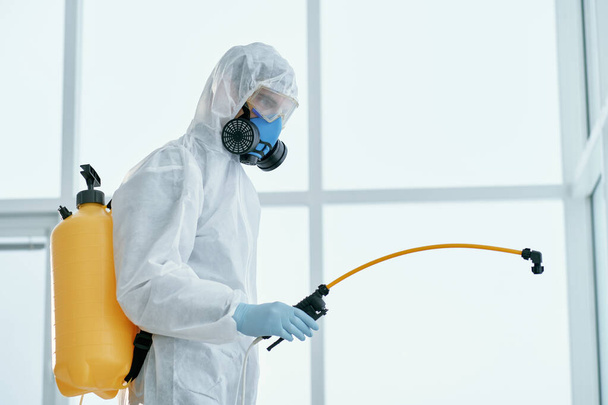 man in a bacteriological protection suit standing in the office . - Photo, Image