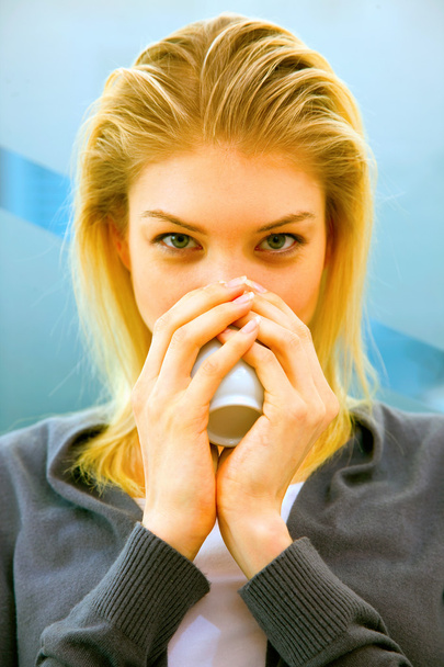 Close-up of blonde young woman drinking tea - Fotó, kép