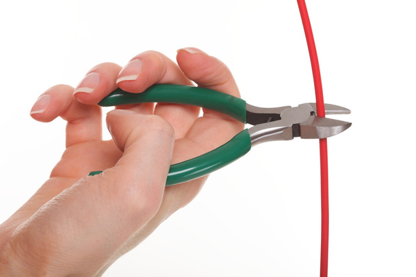 Hand with metal nippers is cutting cable - Foto, Imagen