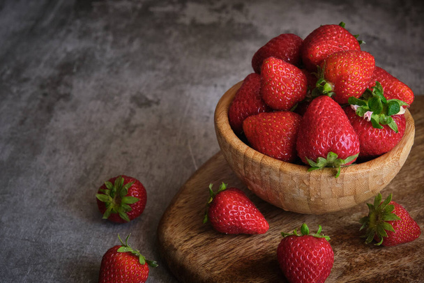 fraises dans un bol en bois sur fond gris - Photo, image