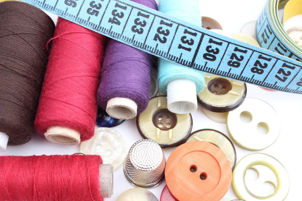Colorful spools of thread, tape measure, thimble and buttons - Photo, image