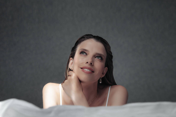 Woman middle aged relaxing on comfortable soft bed in bedroom at cozy home or hotel, calm satisfied female relaxed on couch. Concept of comfort, privacy and relaxation. Copy space - Φωτογραφία, εικόνα