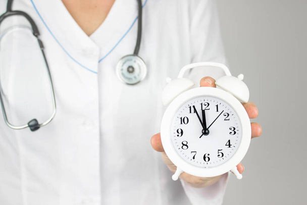 Time is crucial life saver. Concept for timing, medical and healthcare. Alarm clock in doctor hand. Time to take care of your health - Photo, Image