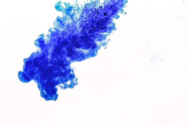 Blue ink injected into water from syringe, colour mixing with water creating abstract shapes, banner with space for text right side - Фото, изображение