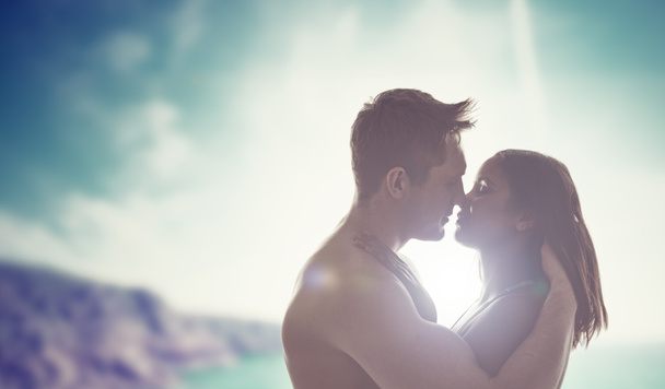 バックライト付き太陽によってキス若いカップル - 写真・画像