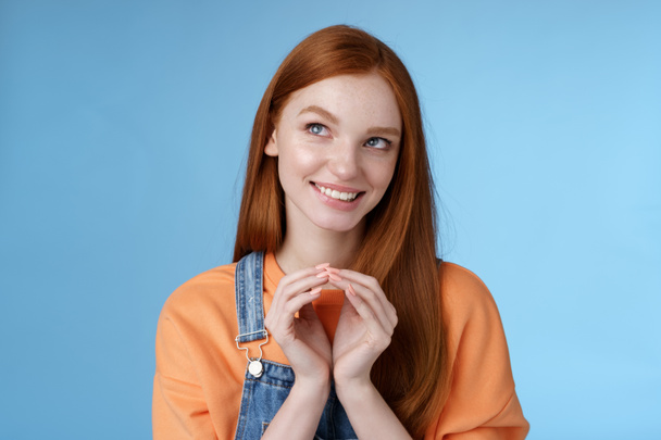 Devious tricky smart pretty redhead girlfriend have evil plan smirking mysteriously look upper left corner twiddles fingers think excellent plan, smiling delighted, standing blue background - Photo, Image