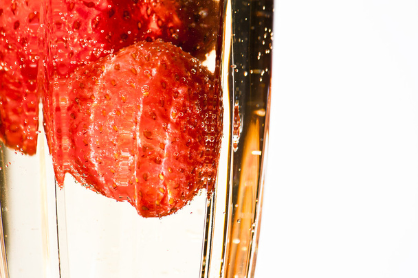 Champagne poured over strawberries in an elegant cut crystal champagne glass - Photo, Image