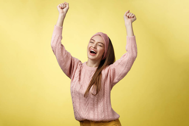 Pozitivní slaví šťastný evropský mladý žena na sobě ležérní svetr křičí šťastně křičí ano, triumfující závodní ruce v úspěchu skákání extázi radovat se z úspěchu - Fotografie, Obrázek