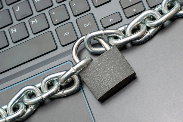железная цепь, закрепленная замком на клавиатуре компьютера, концепция цензуры защиты данных в Интернете. Высокое качество фото - Фото, изображение