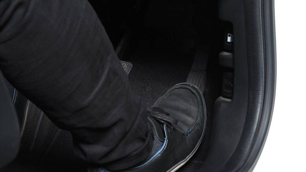 Man foot and accelerator and brake pedal inside the car or vehicle and copy space which black color leather shoe stepped on it for speed up or control automobile pace power. Automobile Driving concept - Photo, Image