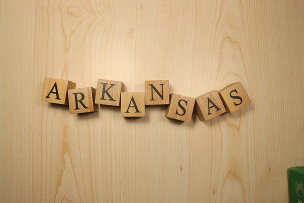 Słowo Arkansas zostało stworzone z drewnianych kostek z literami. Miasta i słowa. zbliżenie. - Zdjęcie, obraz