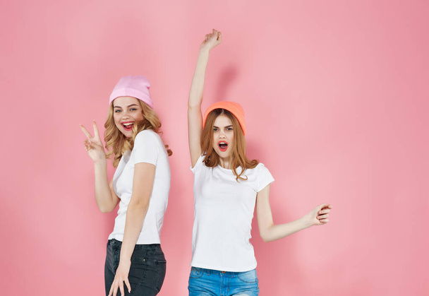 δύο χαριτωμένες φίλες σε μοντέρνα ρούχα νεανικό στυλ ροζ φόντο - Φωτογραφία, εικόνα