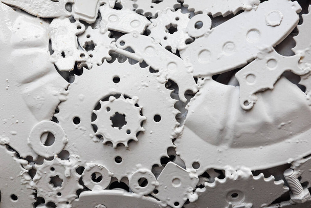 Closeup of metal gears and machine parts painted by white color. Steampunk textured pattern background - Foto, Imagem