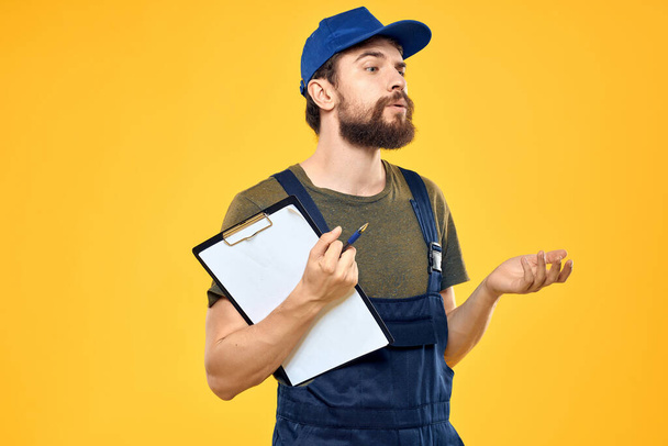 man in work uniform with boxes delivery service yellow background - 写真・画像