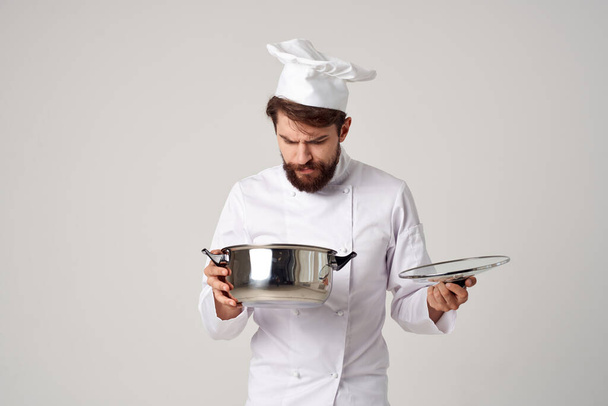 Chef masculino alegre mirando en una cacerola preparando restaurante de comida - Foto, Imagen