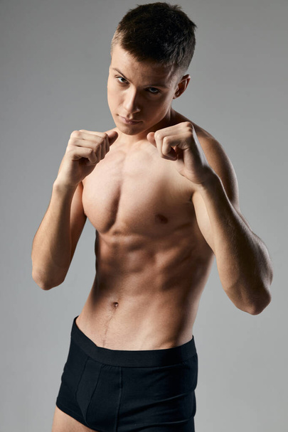 sexy guy athlete naked torso bodybuilder gray background  - Foto, afbeelding
