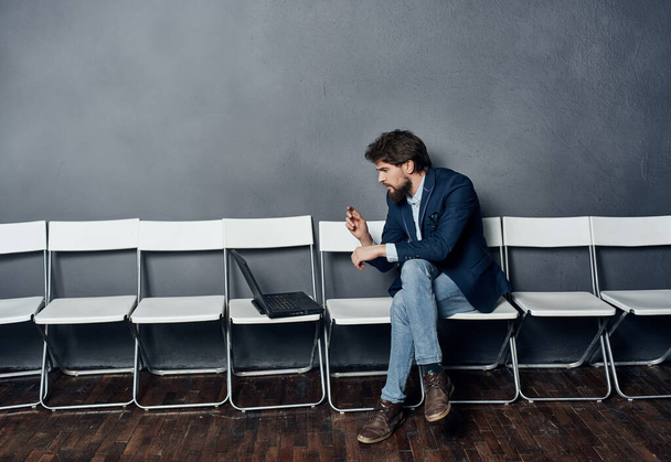 менеджер мужчина с ноутбуком сидит на стуле в ожидании профессионального собеседования - Фото, изображение