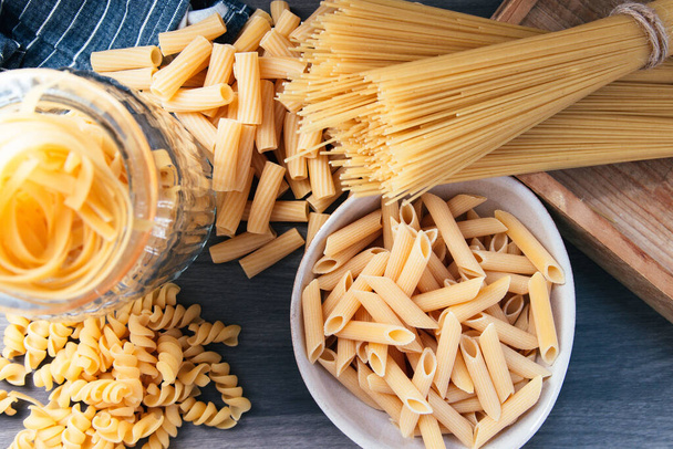 various types of raw pasta in the kitchen - Foto, afbeelding