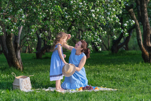 家族のアウトドアライフスタイルと自然シーン。母と娘が公園で遊んでいる。幸せな家族の概念。家庭生活における幸福と調和. - 写真・画像