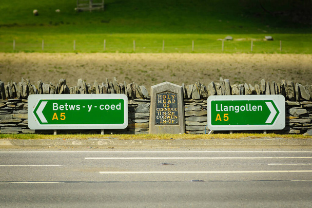 Sinais rodoviários e marco na A5 estrada fora de Corwen entre Betws y Coed e Llangollen no Nordeste do País de Gales Reino Unido - Foto, Imagem