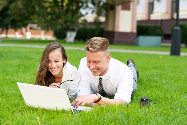 businessman and businesswoman with a laptop in a city park - Fotó, kép