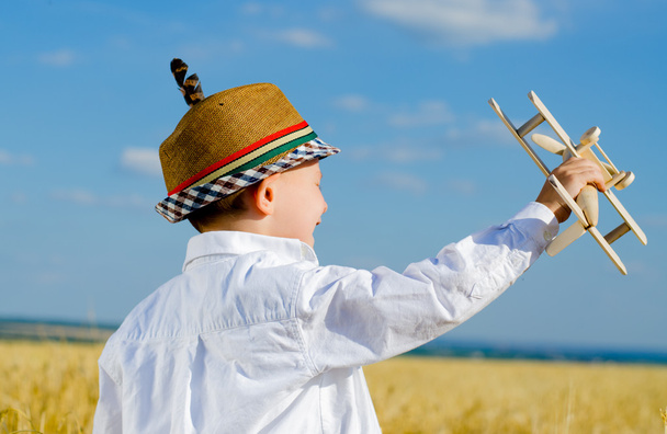 Jeune garçon jouant avec un avion modèle
 - Photo, image