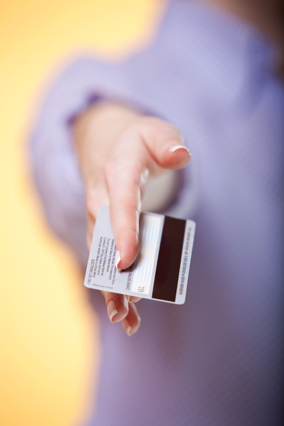 A mão da mulher estendendo um cartão de crédito em oferecer gesto
 - Foto, Imagem