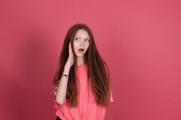 13 éves lány gyerek alkalmi elszigetelt terrakotta háttér pletyka hallgat kézzel fül - Fotó, kép