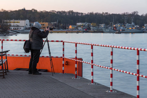 Gdynia, Polonia - 22 de abril de 2016: Un hombre tomando fotos en el puerto de Gdynia, muelle francés. - Foto, imagen