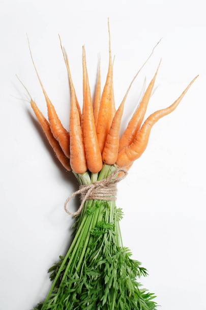 Bouquet de carottes attachées avec une corde sur fond blanc. - Photo, image