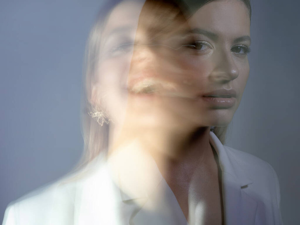 young stylish woman in a white jacket, distortions of the models face - Foto, afbeelding