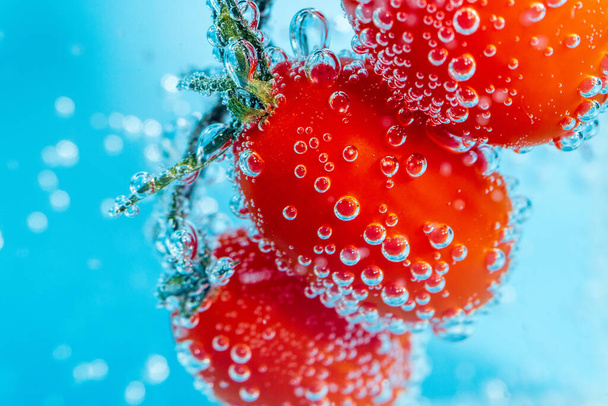 Kirsikkatomaatit lähikuva vedessä veden alla, valikoiva makrofokus - Valokuva, kuva