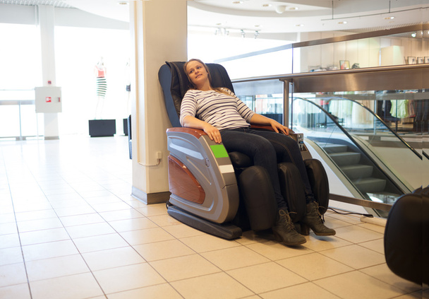 Жінка в масажному кріслі в торговому центрі
 - Фото, зображення