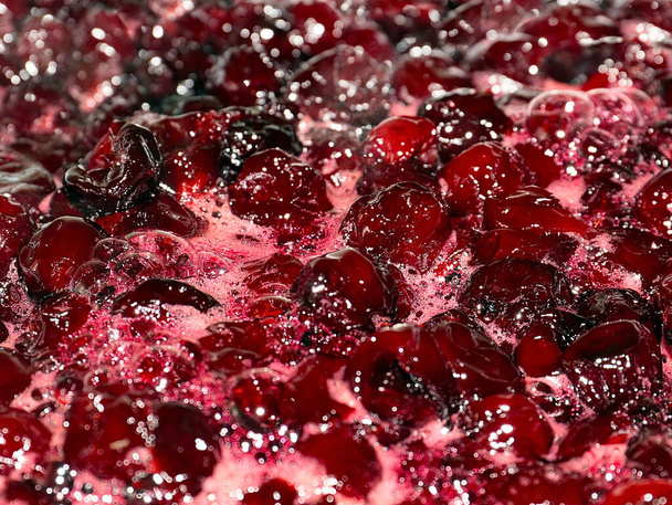 foam and air bubbles on the surface of boiling cherry jam when cooking - Foto, imagen