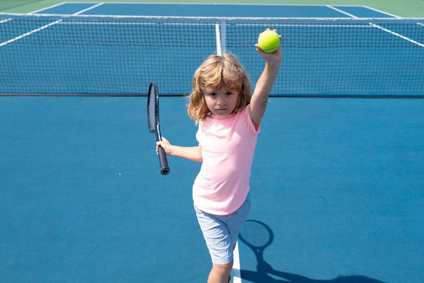 Little boy playing tennis. Sport kids. Child with tennis racket on tennis court. Training for young kid, healthy children. - Foto, Imagem