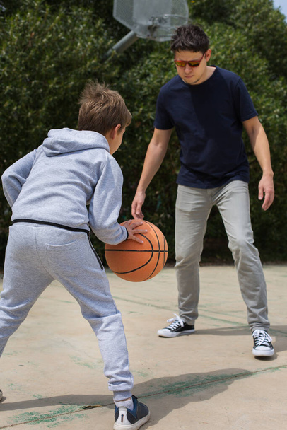Stilvoller kleiner Junge, Teenager spielt mit Ball, im Freien - Foto, Bild