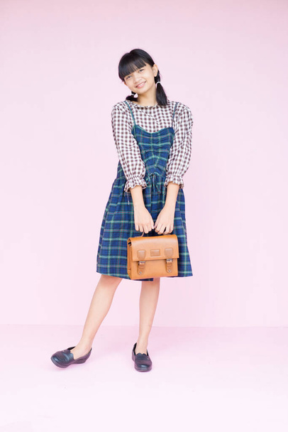 Portrét student youn dívka s úsměvem držet hnědou tašku na růžovém pozadí. - Fotografie, Obrázek